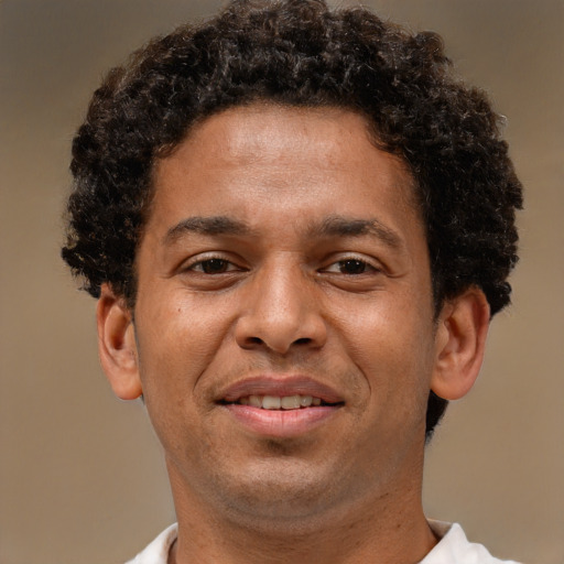 Joyful black adult male with short  brown hair and brown eyes