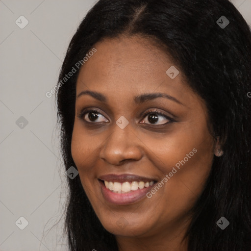 Joyful black young-adult female with long  black hair and brown eyes