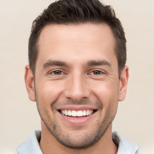 Joyful white young-adult male with short  brown hair and brown eyes