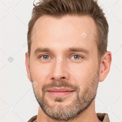 Joyful white young-adult male with short  brown hair and grey eyes