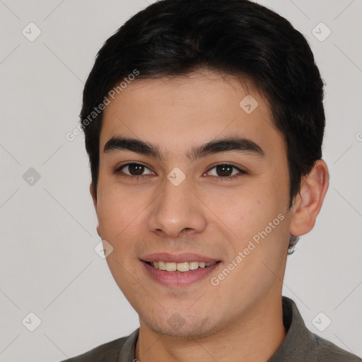 Joyful white young-adult male with short  black hair and brown eyes