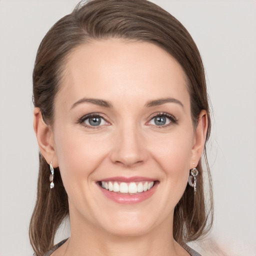 Joyful white young-adult female with medium  brown hair and grey eyes