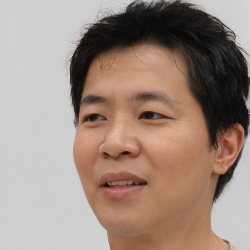 Joyful asian young-adult male with short  brown hair and brown eyes