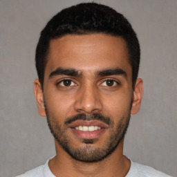 Joyful latino young-adult male with short  black hair and brown eyes