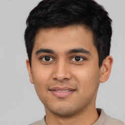 Joyful latino young-adult male with short  black hair and brown eyes