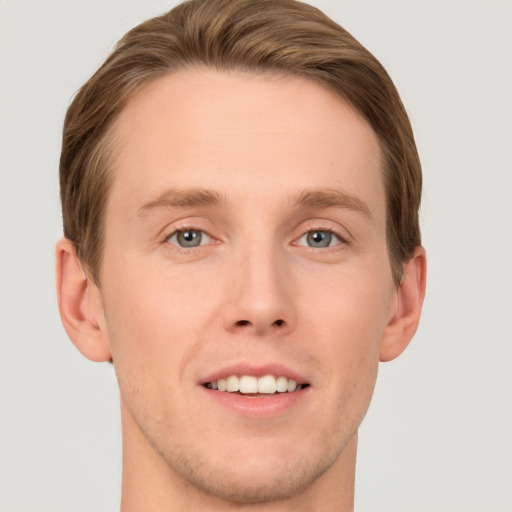 Joyful white young-adult male with short  brown hair and grey eyes