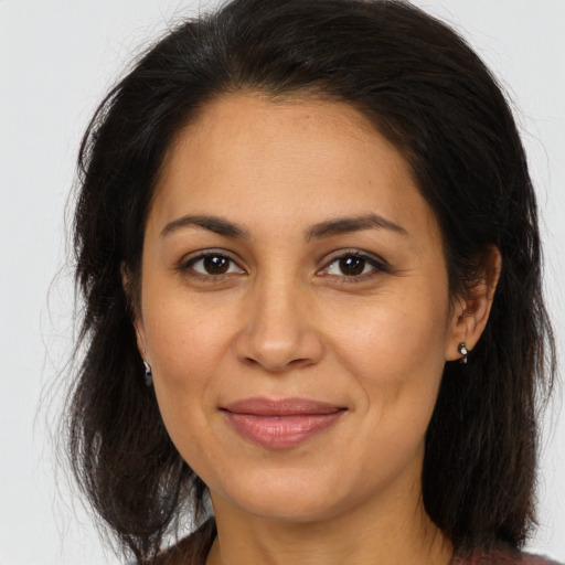 Joyful latino adult female with long  brown hair and brown eyes