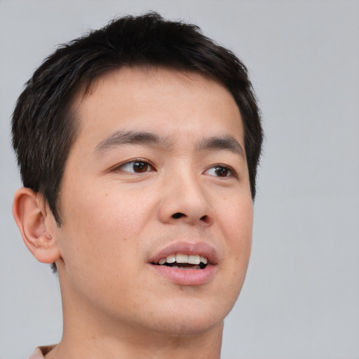 Joyful asian young-adult male with short  brown hair and brown eyes