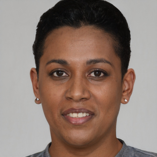 Joyful black young-adult female with short  black hair and brown eyes