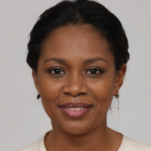 Joyful black young-adult female with short  black hair and brown eyes