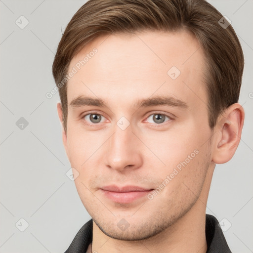 Joyful white young-adult male with short  brown hair and grey eyes