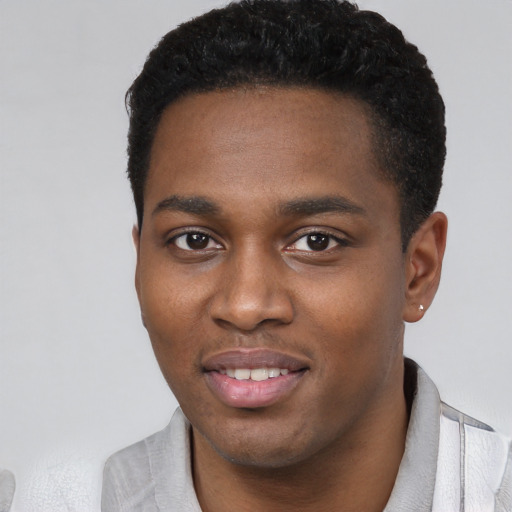 Joyful black young-adult male with short  black hair and brown eyes