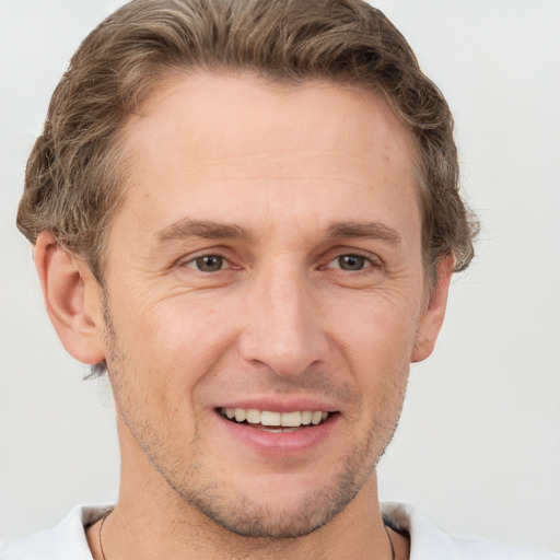 Joyful white adult male with short  brown hair and grey eyes