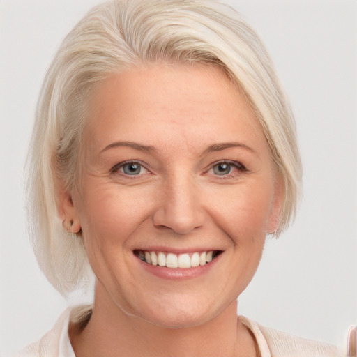 Joyful white adult female with medium  blond hair and blue eyes