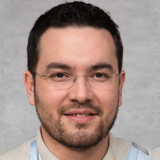 Joyful white adult male with short  black hair and brown eyes