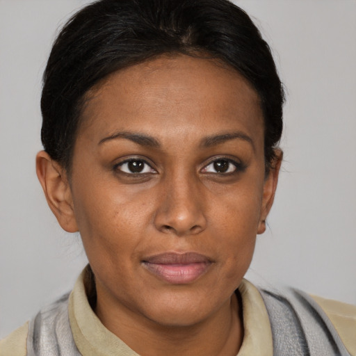 Joyful black young-adult female with short  brown hair and brown eyes
