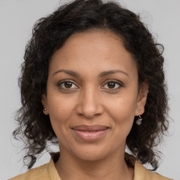 Joyful black adult female with medium  brown hair and brown eyes