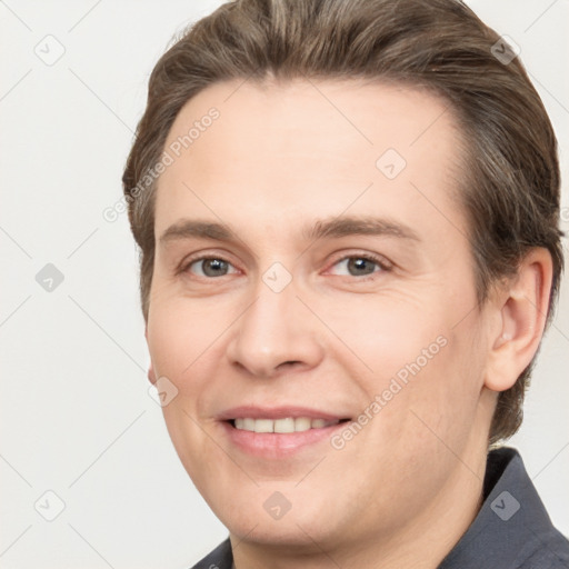 Joyful white adult male with short  brown hair and grey eyes