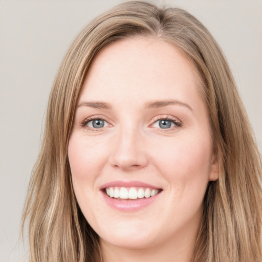 Joyful white young-adult female with long  brown hair and blue eyes