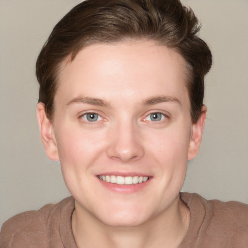 Joyful white young-adult female with short  brown hair and grey eyes