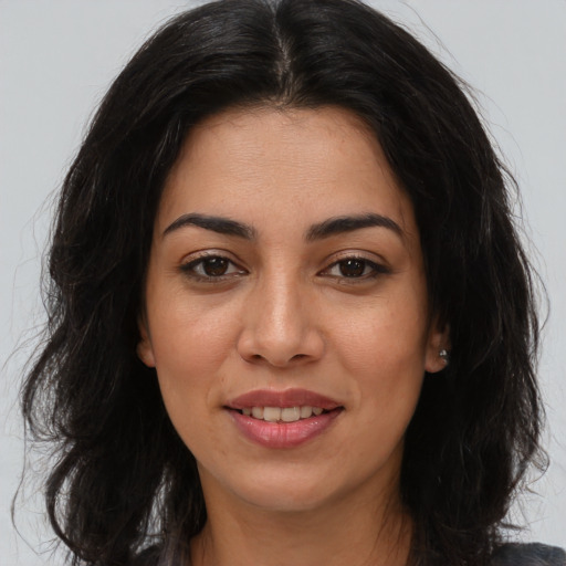Joyful latino young-adult female with long  brown hair and brown eyes
