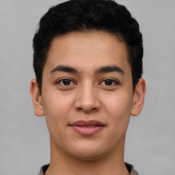 Joyful latino young-adult male with short  brown hair and brown eyes