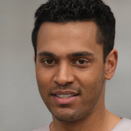 Joyful white young-adult male with short  black hair and brown eyes