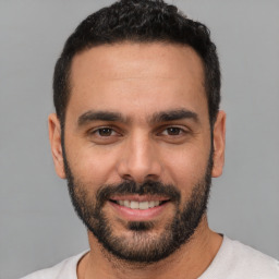 Joyful white young-adult male with short  black hair and brown eyes