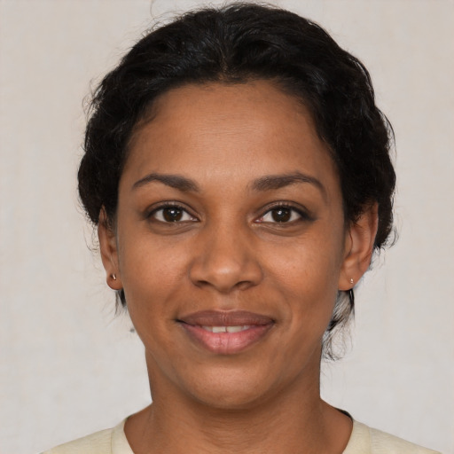 Joyful black young-adult female with short  black hair and brown eyes