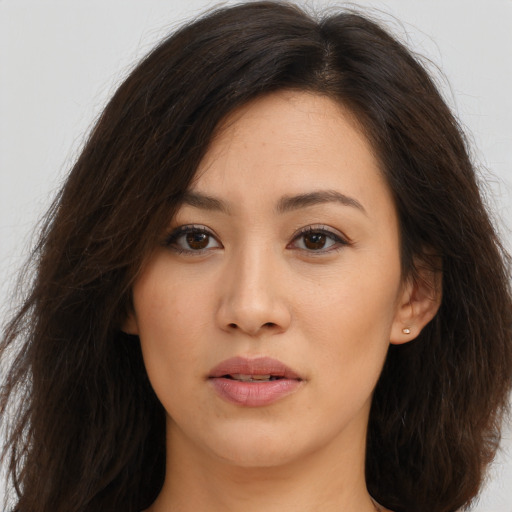 Joyful asian young-adult female with long  brown hair and brown eyes