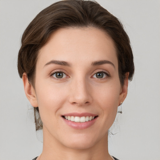 Joyful white young-adult female with short  brown hair and grey eyes