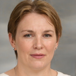 Joyful white adult female with medium  brown hair and grey eyes