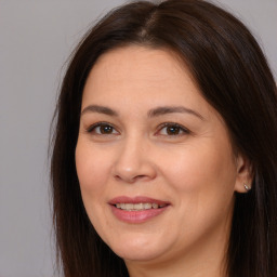 Joyful white adult female with long  brown hair and brown eyes