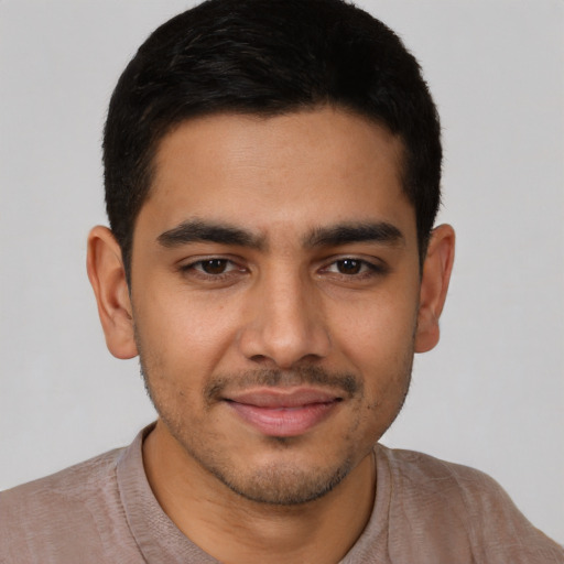 Joyful latino young-adult male with short  black hair and brown eyes