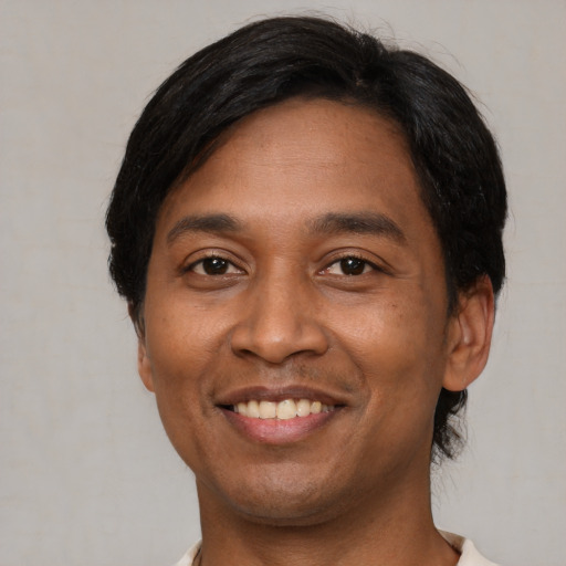 Joyful latino adult male with short  black hair and brown eyes