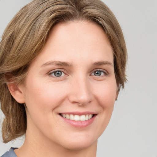 Joyful white young-adult female with medium  brown hair and blue eyes