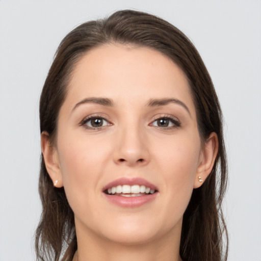 Joyful white young-adult female with long  brown hair and brown eyes