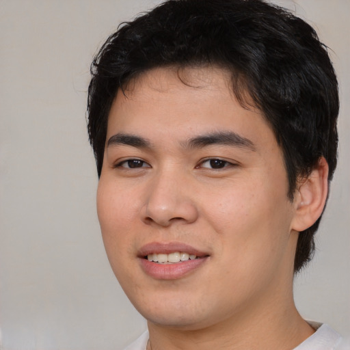 Joyful asian young-adult male with short  brown hair and brown eyes