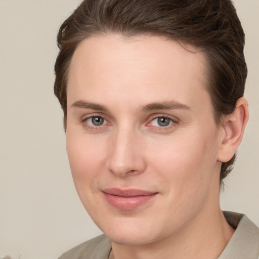 Joyful white young-adult female with short  brown hair and grey eyes