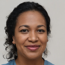 Joyful black adult female with medium  brown hair and brown eyes