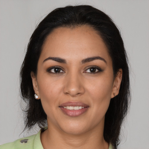 Joyful latino young-adult female with medium  brown hair and brown eyes