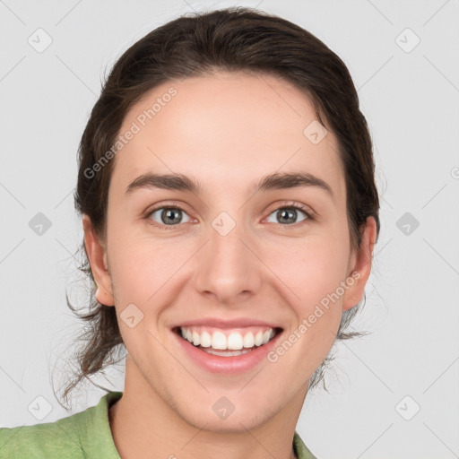 Joyful white young-adult female with medium  brown hair and green eyes