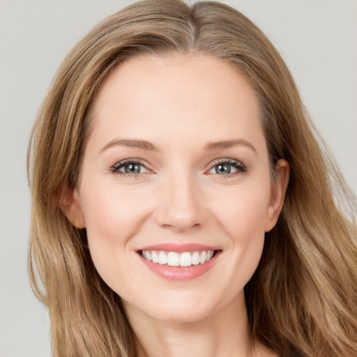 Joyful white young-adult female with long  brown hair and blue eyes