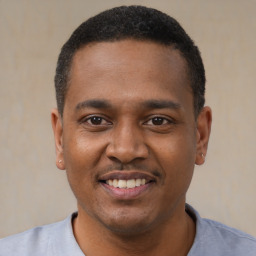 Joyful black young-adult male with short  black hair and brown eyes