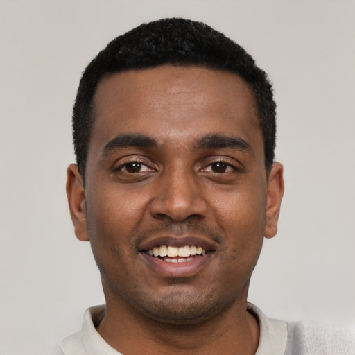 Joyful black young-adult male with short  black hair and brown eyes