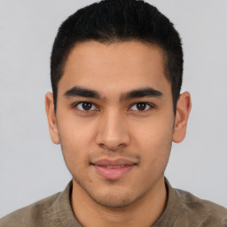 Joyful latino young-adult male with short  brown hair and brown eyes