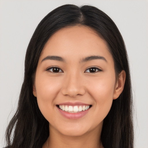 Joyful latino young-adult female with long  brown hair and brown eyes