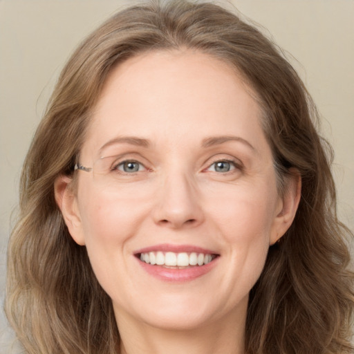 Joyful white adult female with long  brown hair and blue eyes