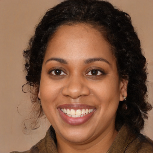 Joyful black young-adult female with long  brown hair and brown eyes