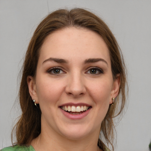 Joyful white young-adult female with medium  brown hair and green eyes